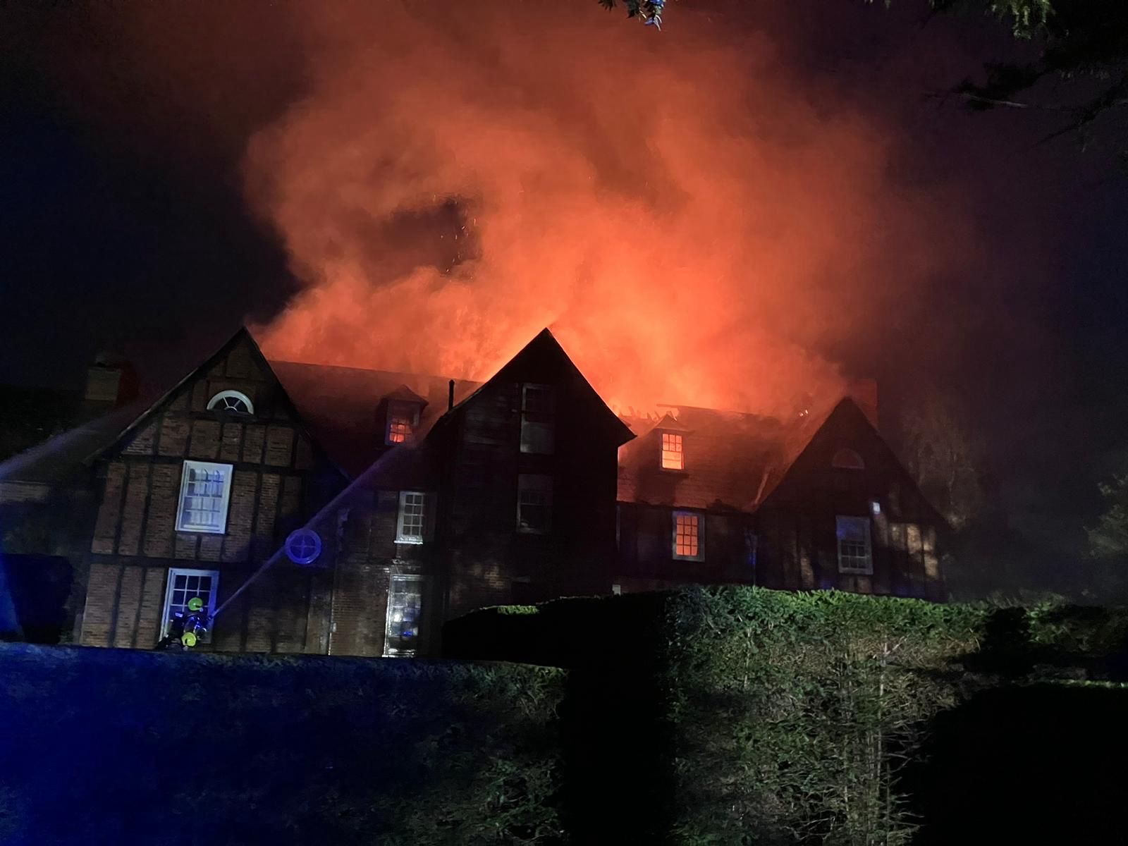 Large house with flames coming from roof